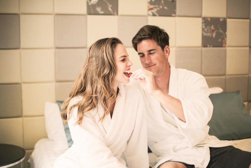 Man en vrouw in badjas elkaar verwennen